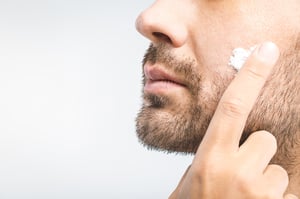 man applying facial serum