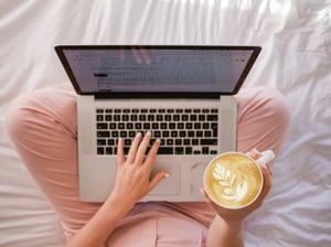 person using laptop in bed