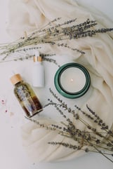 skincare products and candle with lavender sprigs 