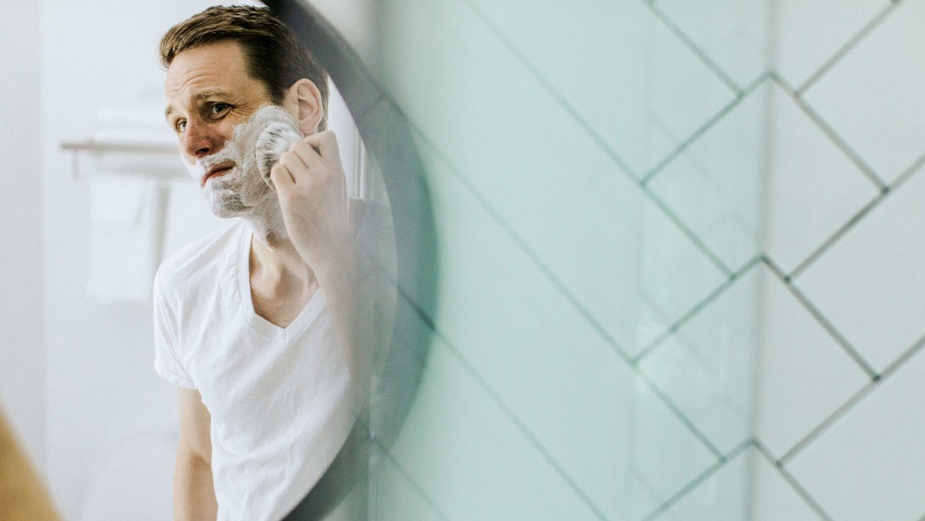 man shaving in mirror